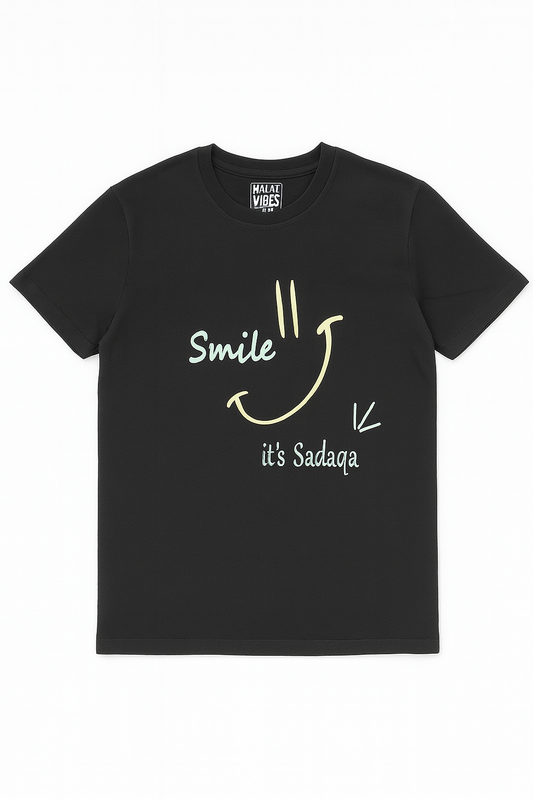 Black t-shirt with a smiley face and text ' Smile it's sadaqa'