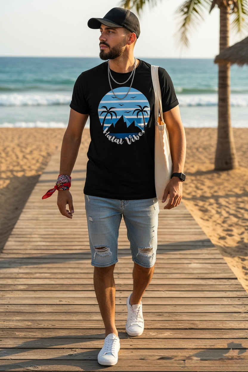 Man walking on a wooden boardwalk by the beach wearing a black t-shirt with a graphic design.