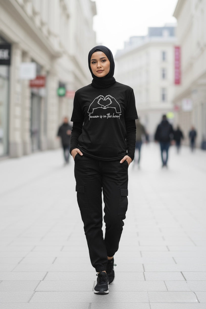 Person wearing a black outfit with text on a city street