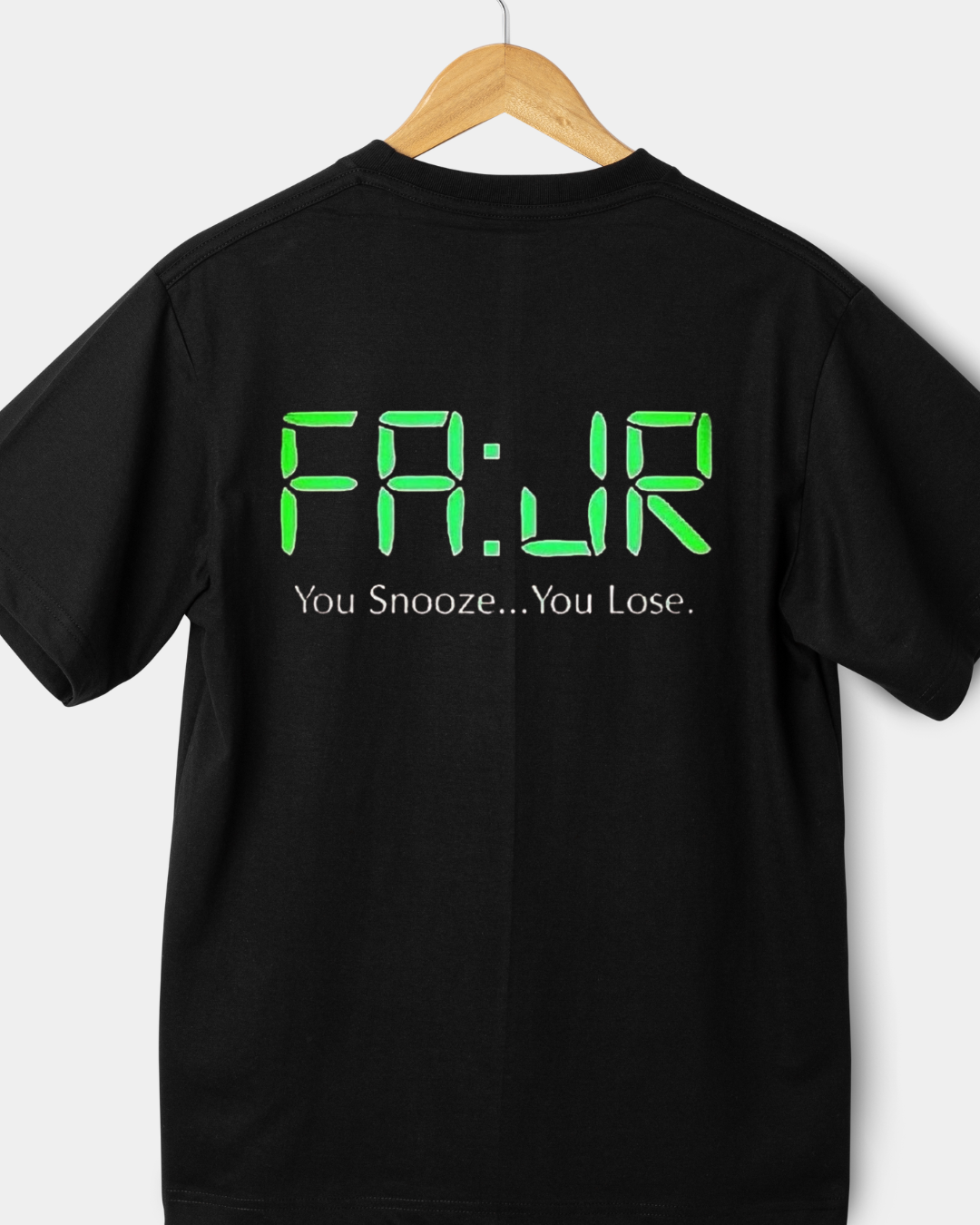 Black t-shirt with green text reading Fajr you snooze you lose on a hanger against a white background