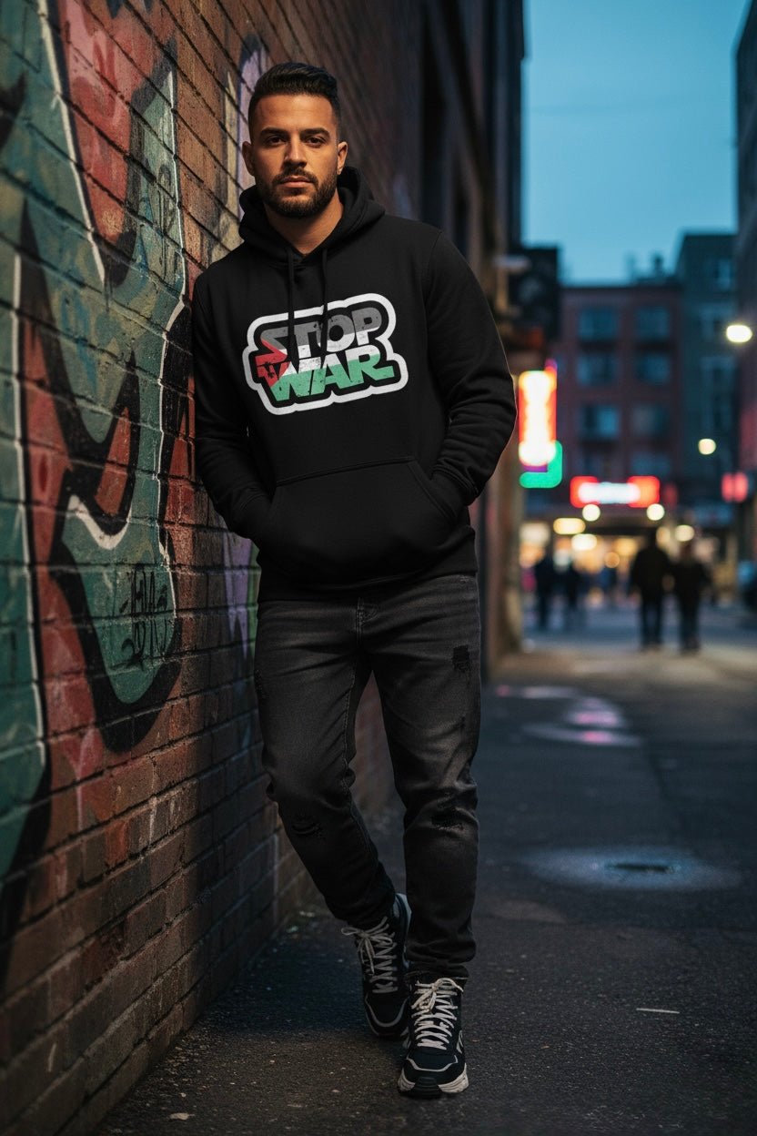 Person wearing a Stop War hoodie standing against a graffiti-covered wall on a city street.