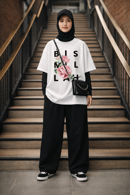 Person wearing a white t-shirt with Bismillah text and floral design, standing on a staircase
