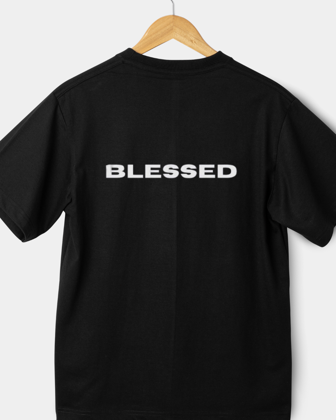 Rear view of a black 220gsm classic fit t-shirt with "BLESSED" in bold white block letters.