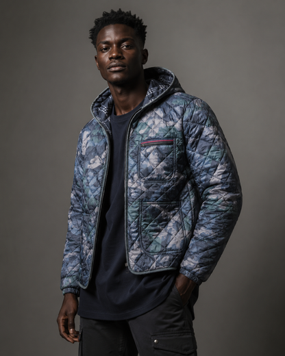 Man wearing a patterned quilted jacket against a gray background