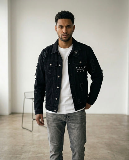 Man wearing a black distressed denim jacket with HV Halal Vibes monogram on the chest. 