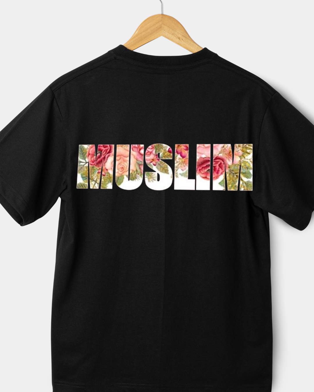 Rear view of a black 220gsm classic fit t-shirt with "MUSLIM" in block letters filled with pink roses and floral patterns.