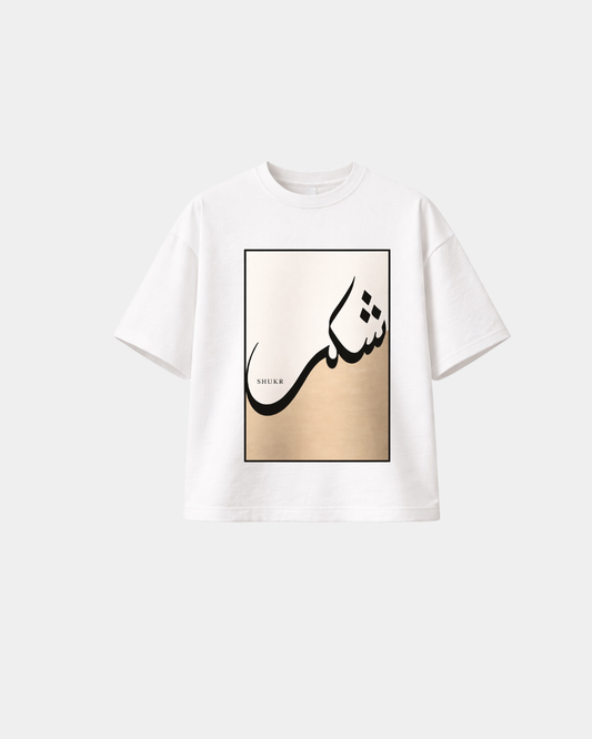 White heavyweight t-shirt featuring a framed sand-gradient box with black Arabic calligraphy for the word Shukr.