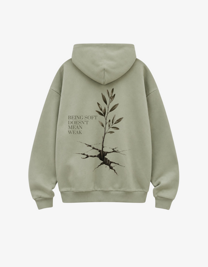 back view showing an olive branch growing out of cracked earth with text Being Soft Doesn't Mean Weak.