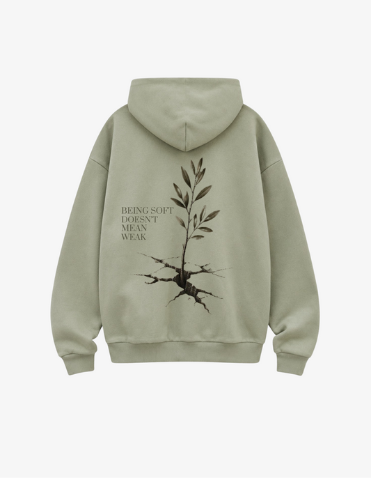 back view showing an olive branch growing out of cracked earth with text Being Soft Doesn't Mean Weak.