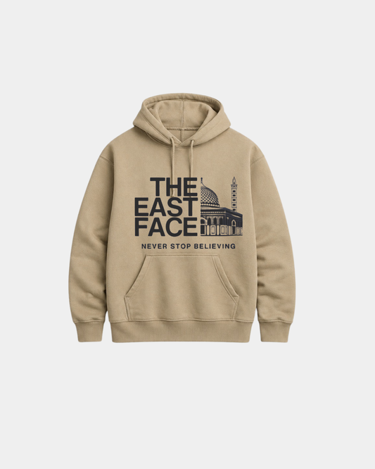 Front view of the Dark Stone heavyweight hoodie from file 2_5.png, featuring the black graphic text THE EAST FACE split with an illustration of Al-Aqsa mosque and the words NEVER STOP BELIEVING.